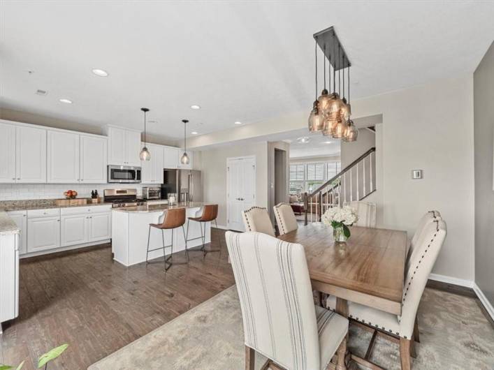 The adjacent dining space is bright and inviting, perfect for both everyday meals and formal gatherings, all set against rich hardwood floors and a neutral color palette.