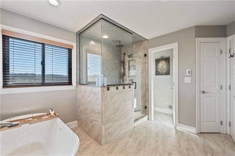 spacious shower with  3 shower heads - fan in shower - built in bench