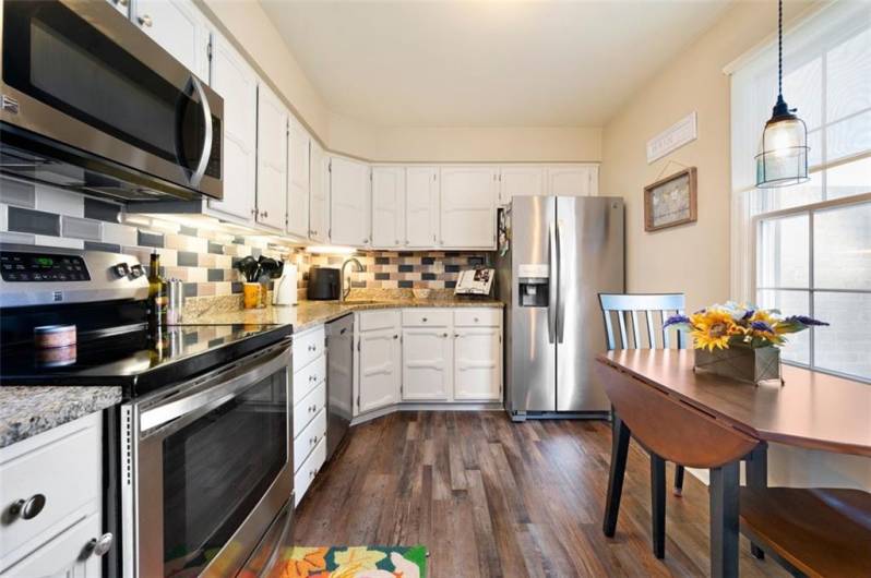 Updated kitchen with newer stainless steel appliances, granite counters, sink, backsplash and floors