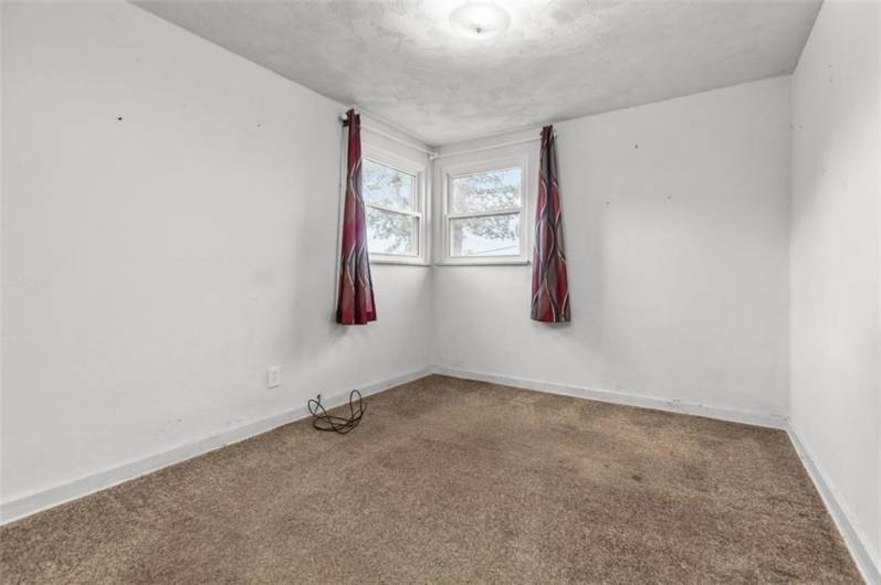 Main floor bedroom (BR 5) with a closet and overhead lighting. Hardwood beneath carpeting.