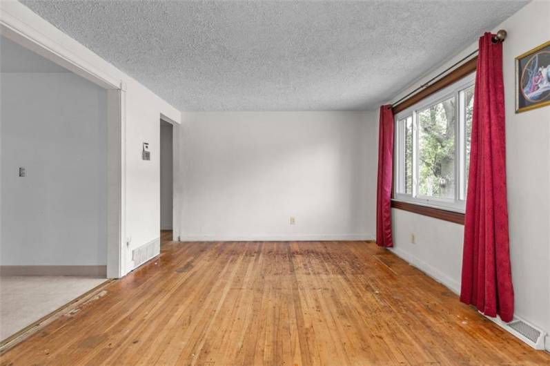 Combination living room-dining room is light and bright...refinish the hardwood flooring to bring it to it's glory!