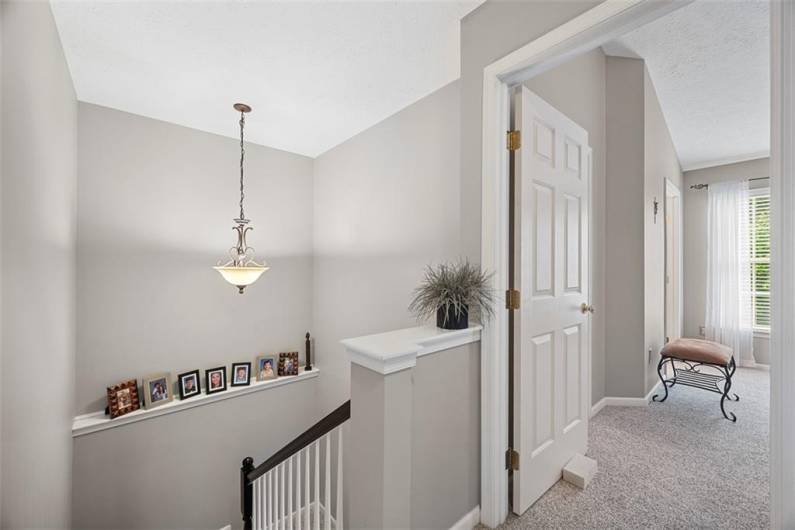 This grand 2 story staircase done in those same soft tones leads to the second floor.