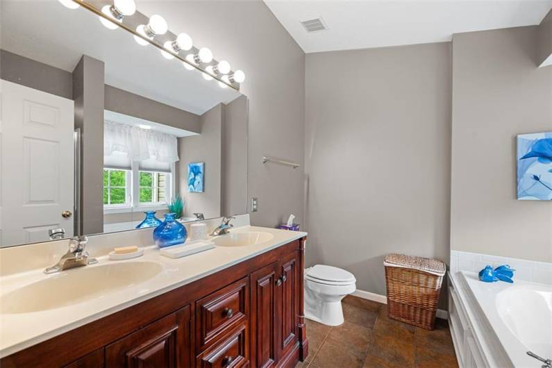 The master ensuite offers a dual vanity, tile flooring and a double window to filter in natural light.