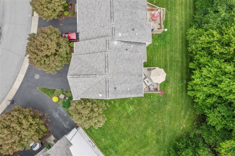 This aerial shot shows the end unit and the nice yard space that surrounds it as well as the tree lined private backyard.