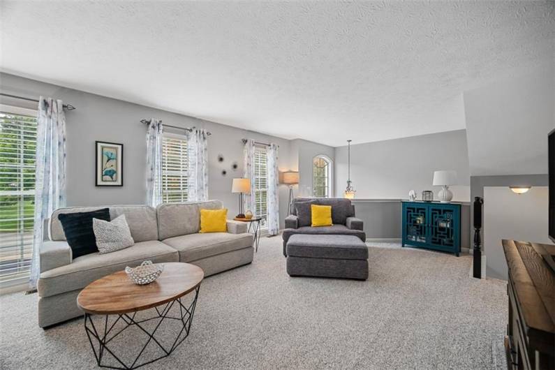 The newer carpet flows throughout the room, light gray tones adorn the walls and 3 floor to ceiling windows filter in ample lighting.