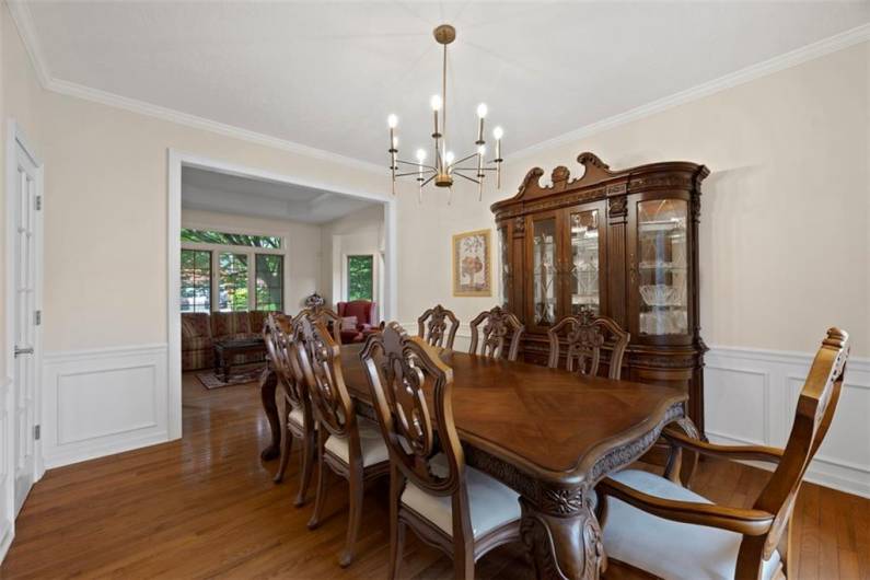 Elevate every meal in this formal dining room, where detailed wainscoting and crown molding create a backdrop of timeless elegance