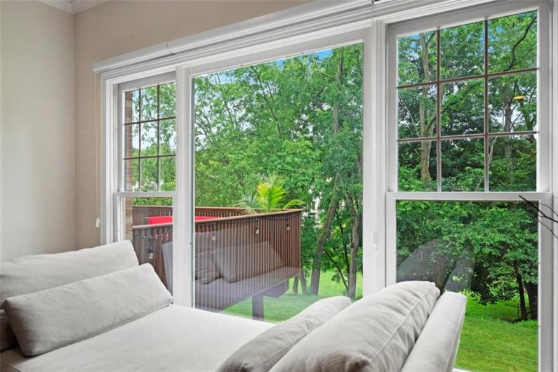 Live surrounded by nature in this breathtaking family room, where expansive picture windows bring the woods inside