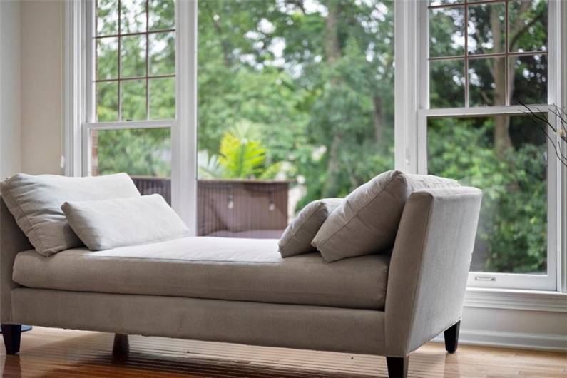 This family room’s vast picture windows create a seamless connection to the peaceful woods outside