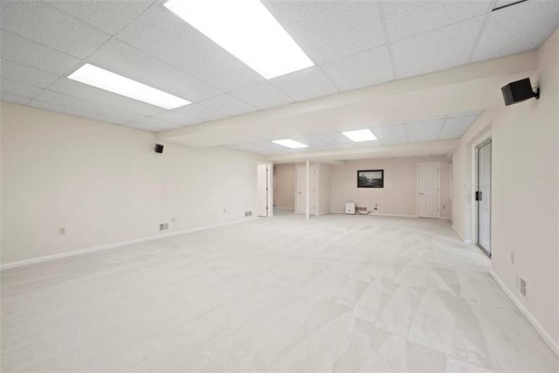An expansive finished lower level with walk-out access to a private patio and lush yard—ideal for entertaining, relaxation, or creating your ultimate retreat