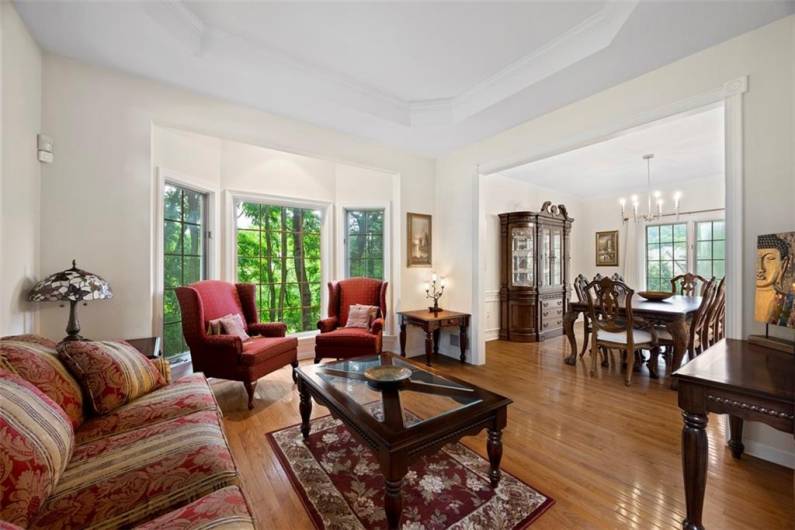 Gleaming hardwood floors unify the open-concept living and dining spaces, creating an inviting flow