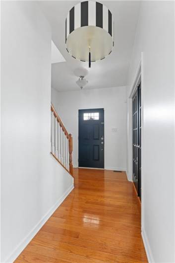 Modern chandelier and hardwood in entry
