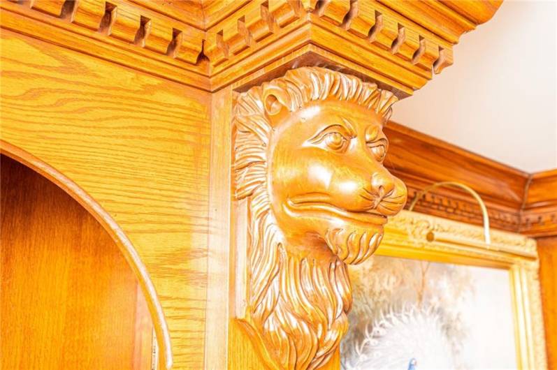 Handcrafted lions heads on the molding in study.