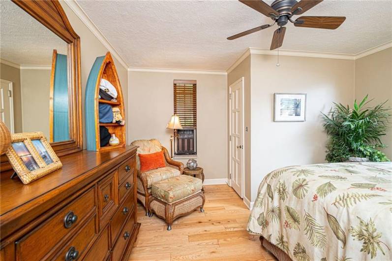 Airy secondary bedroom with hardwood floors and lovely moldings.
