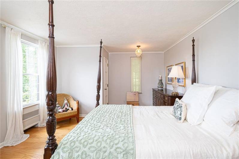 Bright and spacious secondary bedroom with beautiful moldings and hardwood floors.