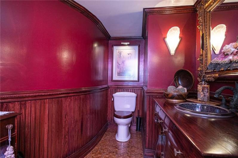 Half bath off of the theatre room. The charm of the wainscoting detail and beautiful hand crafted sink.