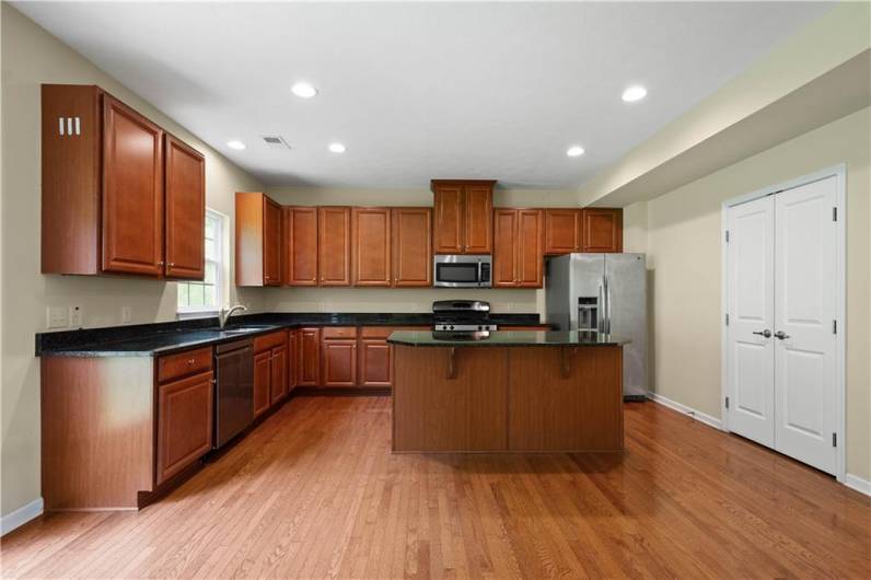 The kitchen offers beautiful cabinetry, kitchen island, granite counters, stainless steel appliances, canned lighting, and a spacious pantry!