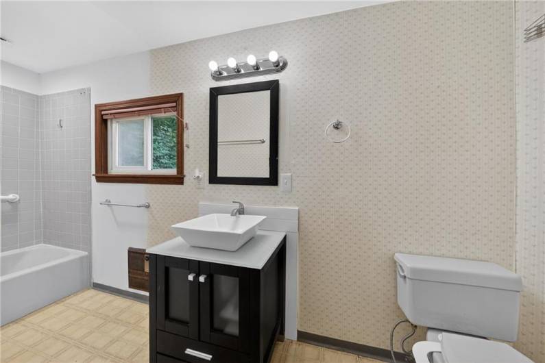 The primary bathroom has been slightly remodeled with a brand new vanity and freshened shower!