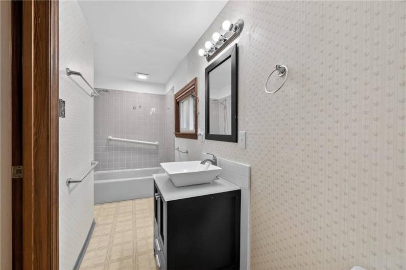 The primary bathroom has been slightly remodeled with a brand new vanity and freshened shower!