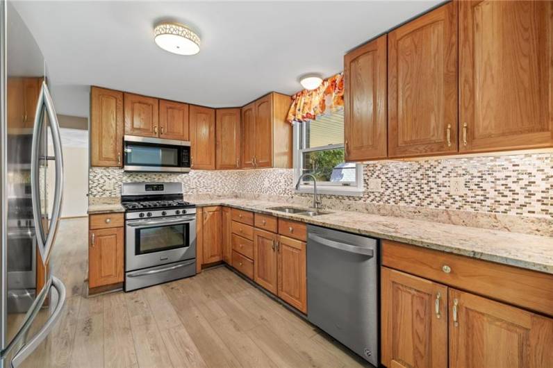 The well-equipped kitchen features newer appliances, backsplash and granite countertop.