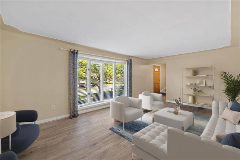 Natural light streams through the floor to ceiling bay window.