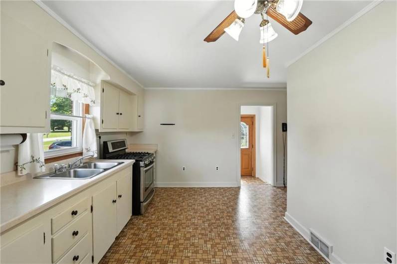 spacious eat in kitchen with gas stove and refrigerator