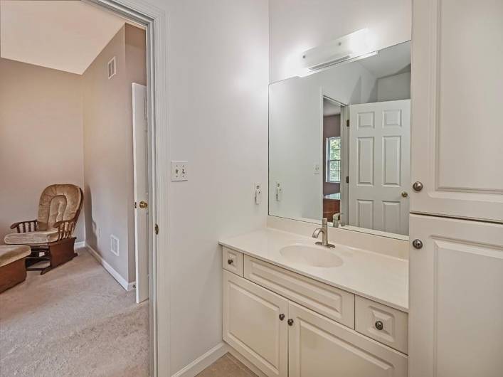 Wood cabinetry, single vanity and linen/toiletry storage.