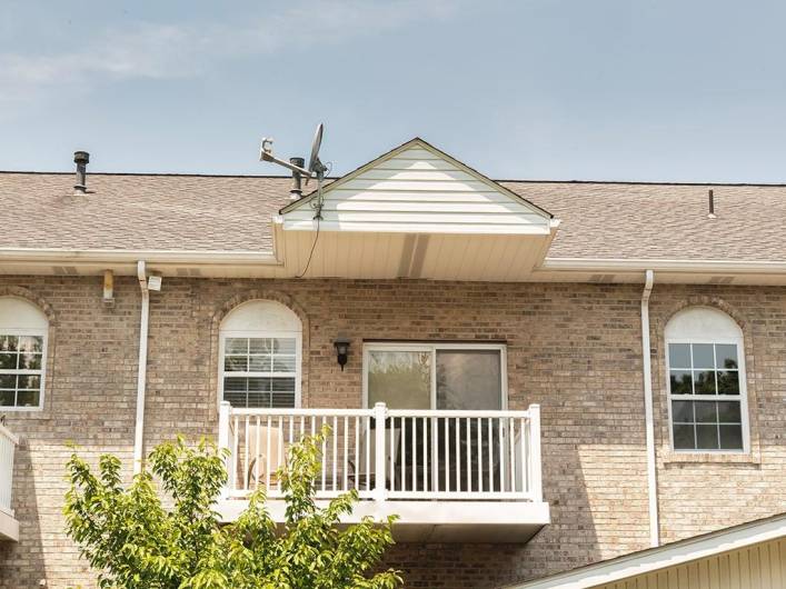 Balcony deck overlooks greenspace.