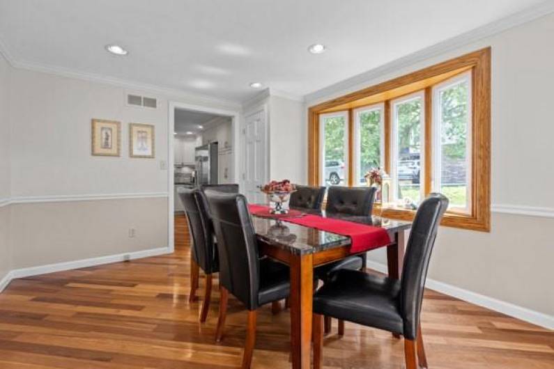 Recessed lighting, chair rail, bay window and nearby coat closet.