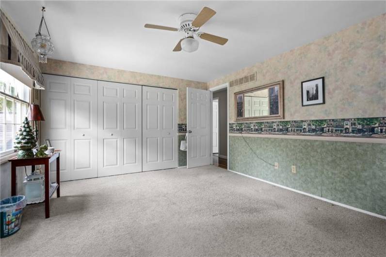 This very large 4th bedroom has as a wall of closets and ceiling fan.