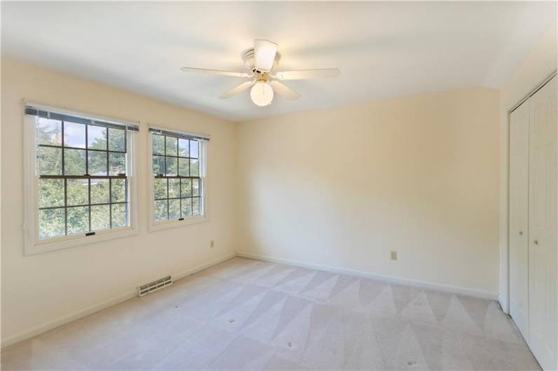 Upper bedroom offers double closet space and extra attic storage.