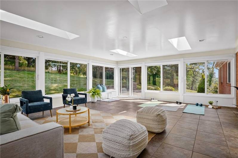 Enjoy the beauty of the outdoors from the comfort of the sunroom, where expansive windows and skylights bring in the sunshine and offer peaceful views of the backyard—an ideal spot to unwind, sip your morning coffee, or watch the seasons change.