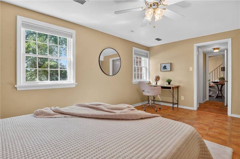 An inviting lower-level room that can be used as a 4th bedroom with terracotta floor tiles and neutral walls.