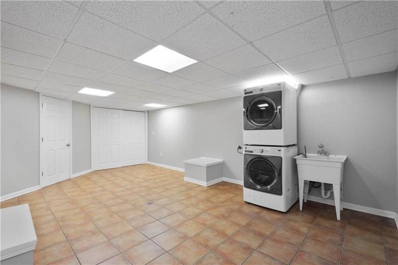 The laundry area offers an abundance of space, making it easy to tackle daily chores with room to spare for sorting, folding, or adding extra storage. It's a practical and flexible setup to keep things organized and efficient.