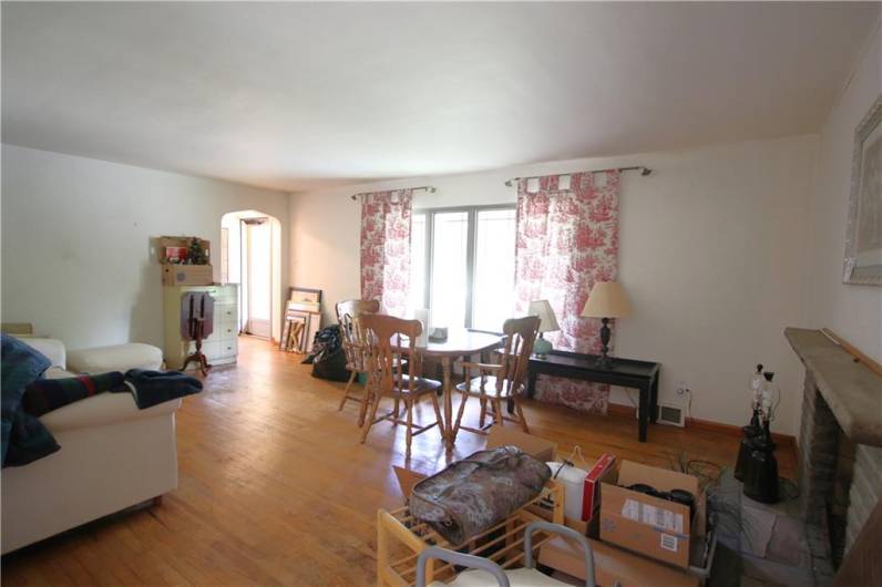 Large 21x14 Living Room w/ Original Hardwood Floors & Oversized Front Picture Window calling in the Natural Light! Stunning Stone Wood Burning Fireplace, Plaster Walls & Marble Widowsills