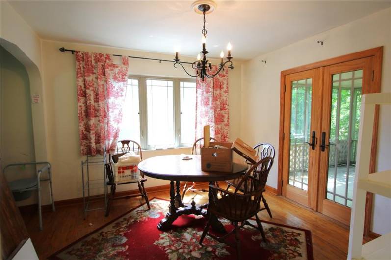 Separate 11x10 Formal Dining Room w/ Nice Big Window & Glass French Door to 24x13 Screened-in Porch. Attractive Candle Style Chandelier & Continuing w/ Hardwood Floors, Plaster Walls & Marble Sills