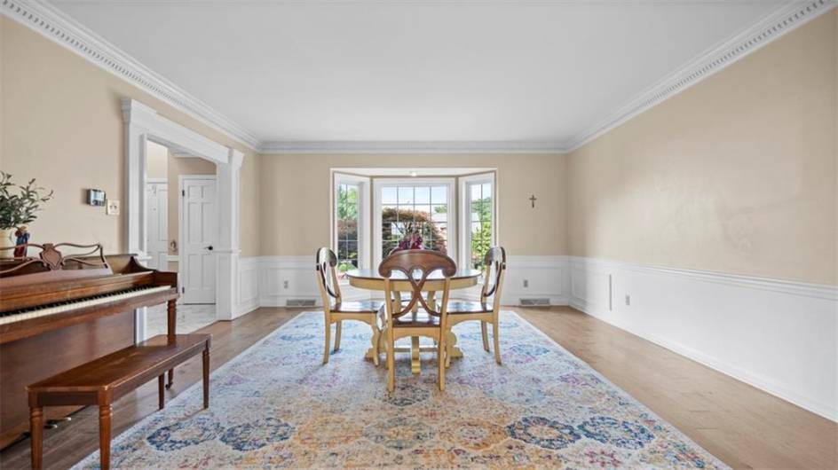 High quality Luxury vinyl floors, wainscoating, Dentil moulding adn walk in angled bay window grace this magnificient room!