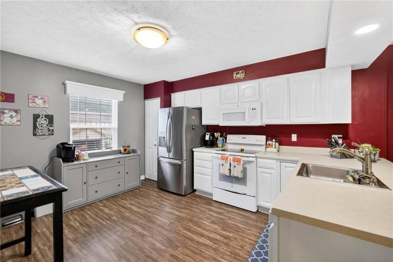 The spacious kitchen has been nicely remodeled with newer flooring and appliances.  The cabinets above the sink were removed to open up the space.