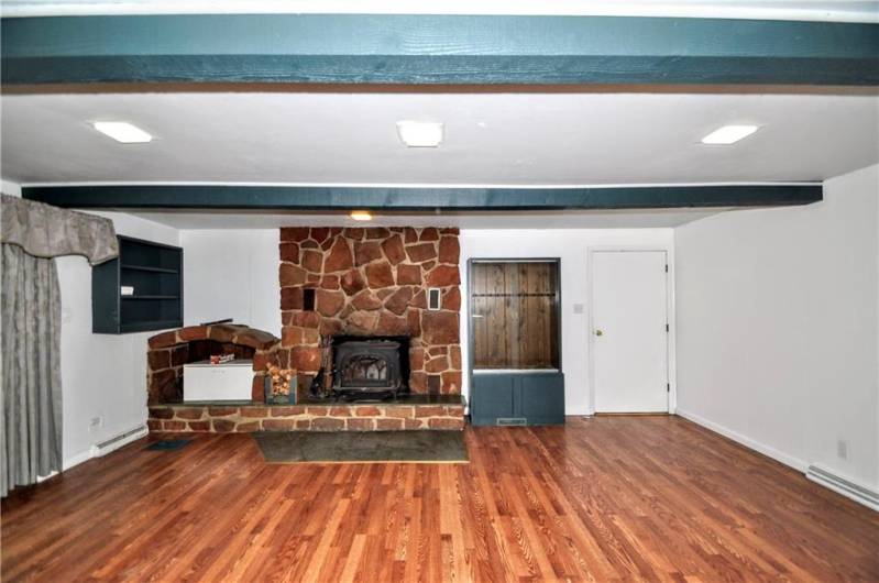Stunning Stone Wood Burning Fireplace w/ Sliding Glass Door to Backyard & Door to Attached Garage plus 2 Attractive Wood Beams. Newer Flooring & Freshly Painted