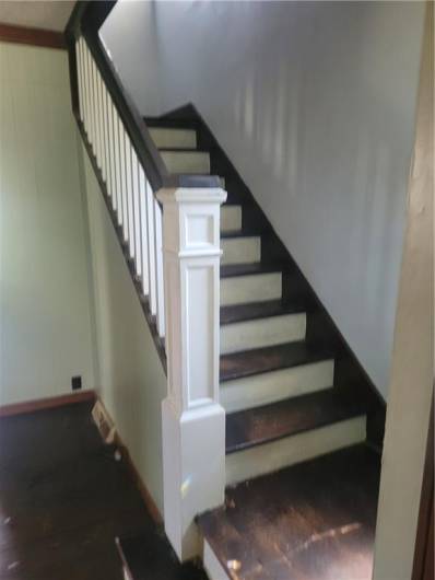 Wood steps going to 2nd floor.  Flooring on main level needs replaced.