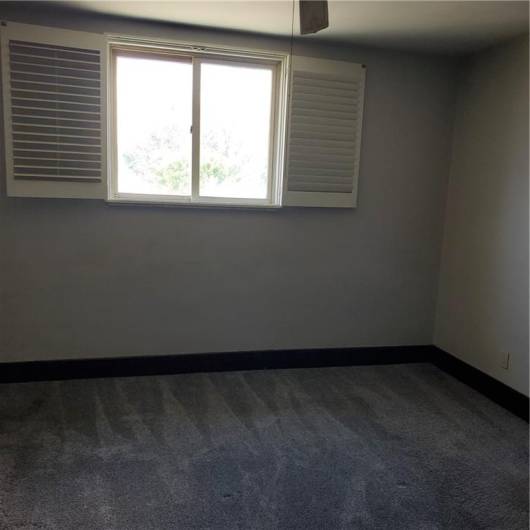Master bedroom with newer carpet and plantation shutters.