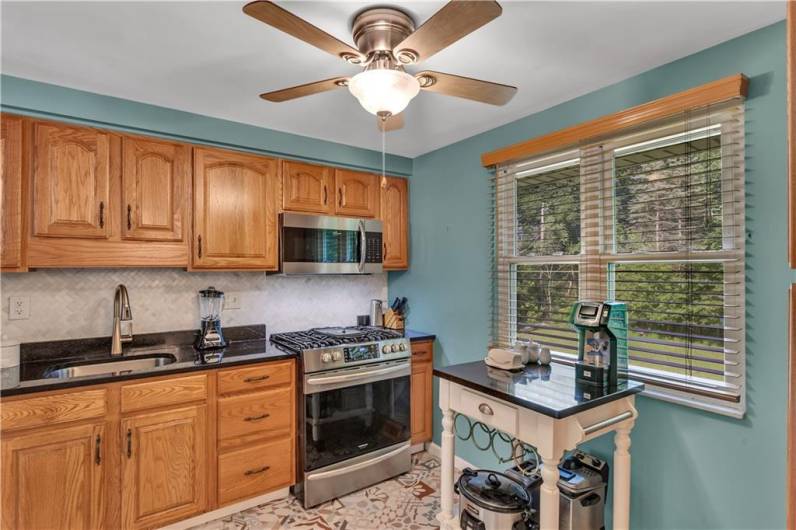 The kitchen has been updated with new flooring, Granite Countertops, backsplash newer Gas stove, microwave and dishwasher