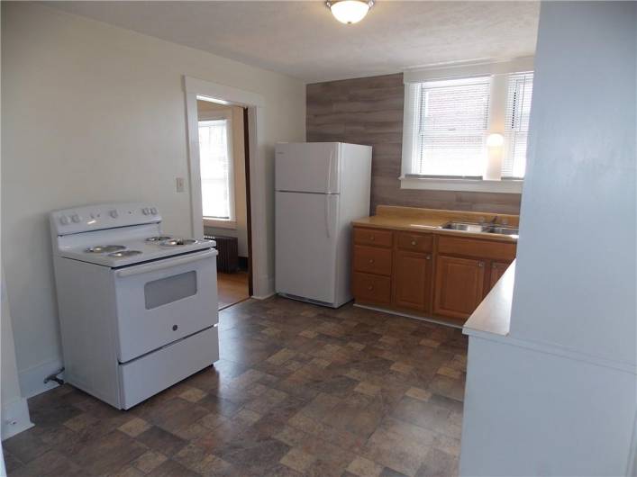 spacious kitchen with a good amount of cabinets, includes ele stove and refrigerator.