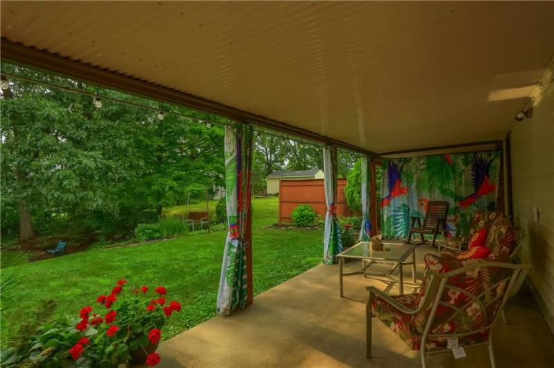 Relax on the covered patio with underdecking, accessible from the basement laundry room, and enjoy peaceful views of the lush backyard. A perfect spot to unwind or entertain, rain or shine.