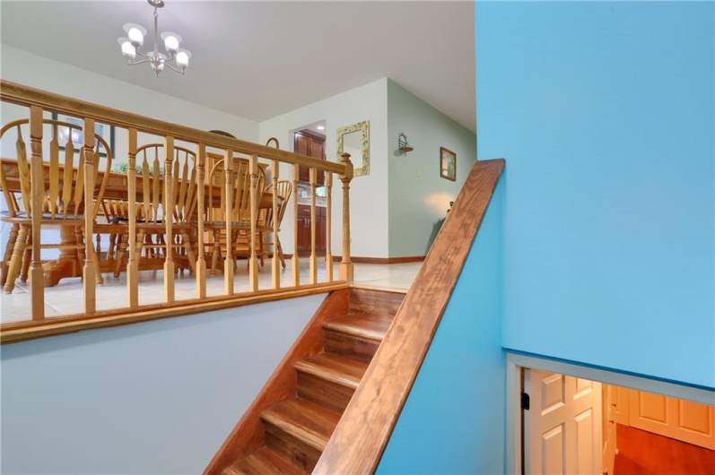 A warm welcome awaits as you enter the home, with rich wood stairs leading up to a spacious dining area filled with natural light and charming traditional details. The open layout flows seamlessly into the kitchen and living spaces beyond.