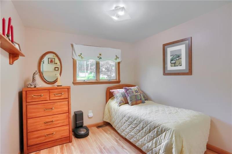 This cozy bedroom features warm wood accents, a large window that brings in natural light, and gleaming hardwood floors. It’s a perfect space for a guest room, home office, or peaceful retreat.
