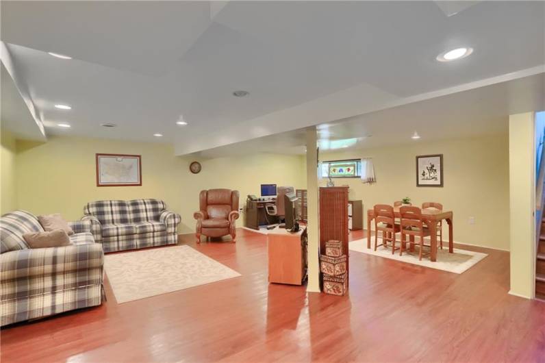 This spacious finished basement offers versatile living with room for lounging, dining, and a dedicated home office setup. Recessed lighting and warm flooring create a comfortable, welcoming atmosphere perfect for entertaining or relaxing.