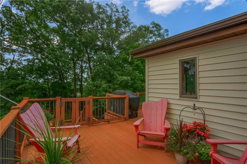 Relax or entertain on the spacious composite deck surrounded by peaceful treetop views and vibrant blooms. Access this deck from the Pella kitchen sliding doors with built in blinds.