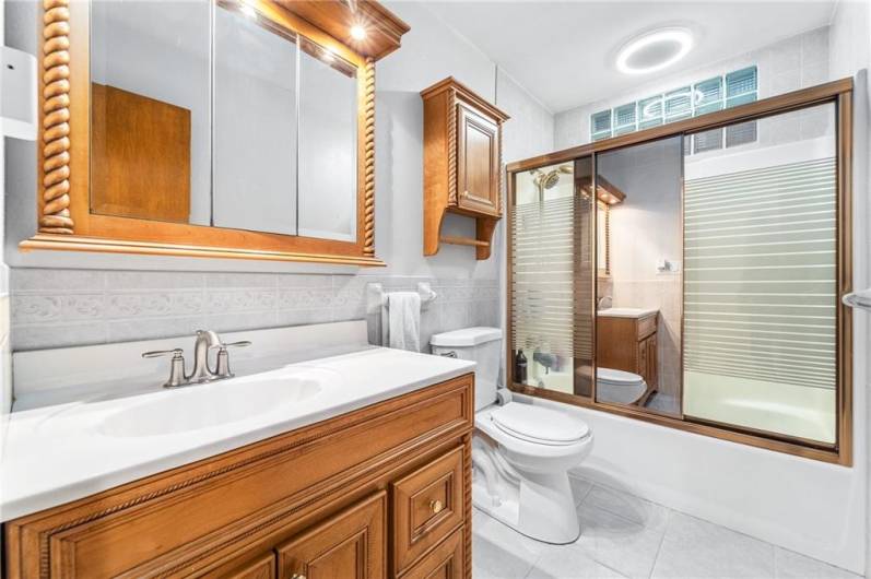 A large vanity and tile floor compliment the white painted walls.