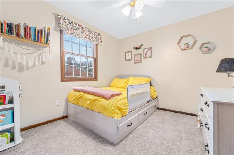 Cheerful thrid bedroom with overhead lighting and neutral tones.