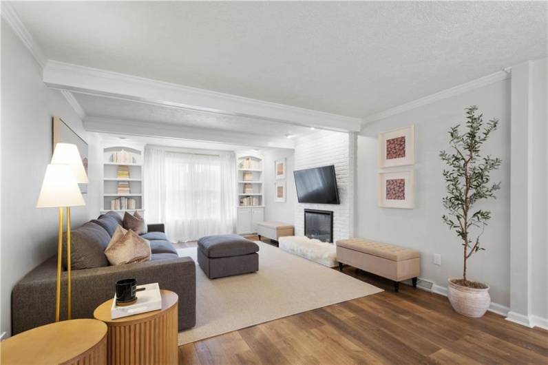 This welcoming family room features charming ceiling beams, a large window framed by custom built-in bookcases, and a fireplace that serves as the perfect focal point.This welcoming family room features charming ceiling beams, a large window framed by custom built-in bookcases, and a fireplace that serves as the perfect focal point.This welcoming family room features charming ceiling beams, a large window framed by custom built-in bookcases, and a fireplace that serves as the perfect focal point.